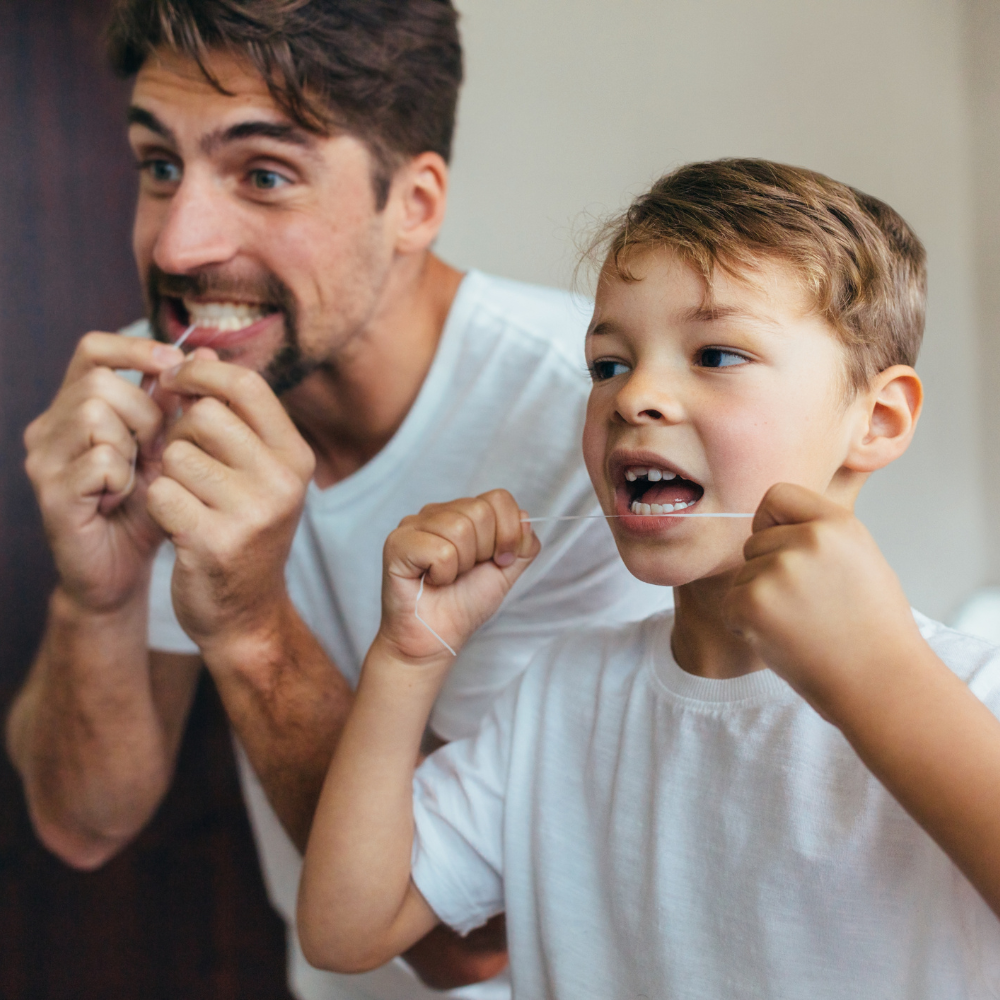 Father and son flossing together.